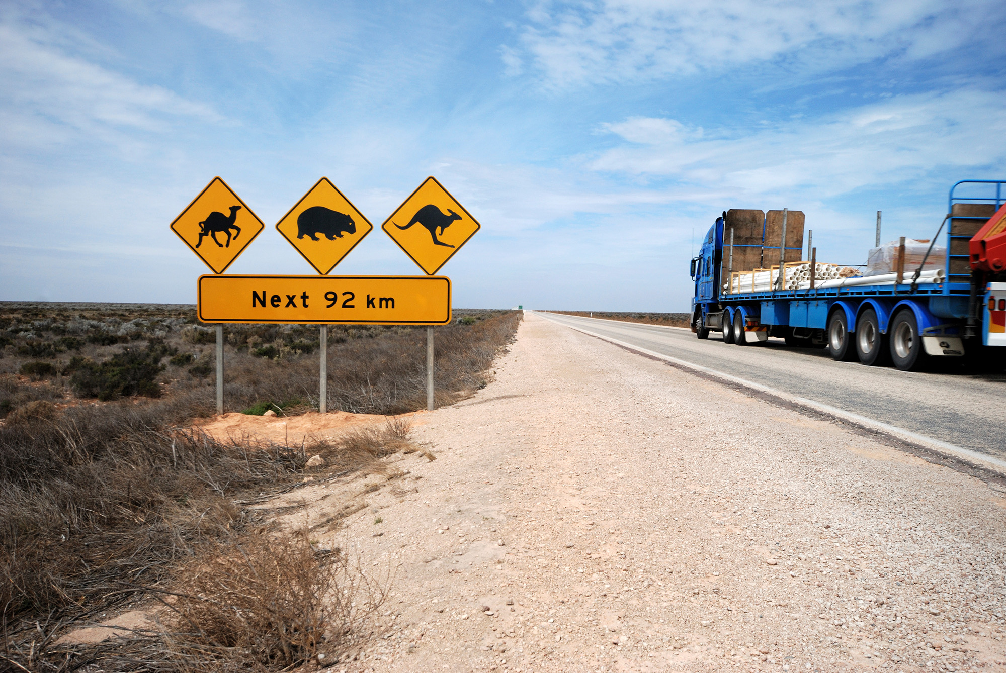 outback road with signage and heavy vehicle